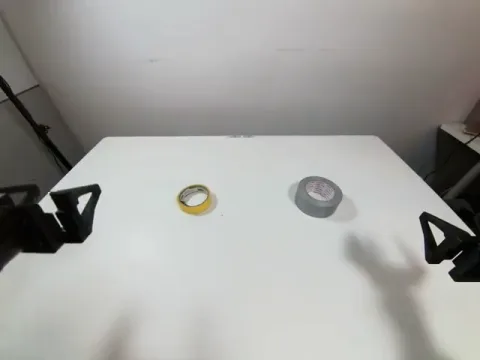 Robot gripper beside the yellow tape roll at the start of the reach